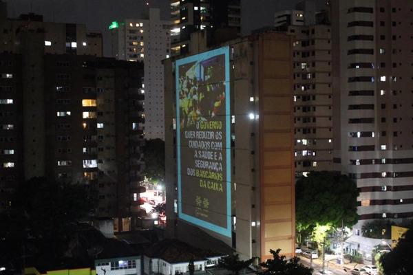 Projeções em prédios denunciam ações do Governo e direção da Caixa para retirar direitos dos bancários